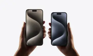 Dwie dłonie trzymają iPhone'y 15 w różnych kolorach. Zastanawiasz się nad ich **pojemnością baterii**?
