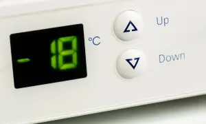 Cyfrowy wyświetlacz pokazuje temperaturę w zamrażarce: -18°C. Obok przyciski "Up" i "Down" do regulacji.