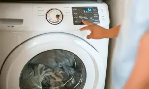 Pralka Whirlpool z włączonym programem. W razie awarii, drzwi można otworzyć awaryjnie.
