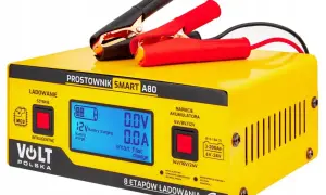 Żółty prostownik Volt Polska Smart A80 z wyświetlaczem, kablem i klemami. Urządzenie oferuje inteligentne ładowanie i rekondycjonowanie akumulatora, co może pomóc w odsiarczanie akumulatora.