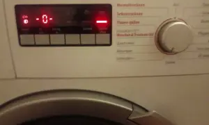 Pralka Bosch z czerwonym wyświetlaczem pokazuje "0" i świecące kontrolki.