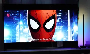 Spider-Man na ekranie telewizora, porównanie technologii QD OLED vs OLED. W tle nocne miasto.
