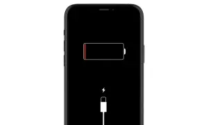 Czarny ekran iPhone'a z ikoną rozładowanej baterii i symbolem ładowania. iPhone nie ładuje się.