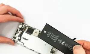Wymiana iPhone'a jest potrzebna, gdy bateria jest zużyta. Dłonie trzymają nową baterię do iPhone'a obok otwartego telefonu.
