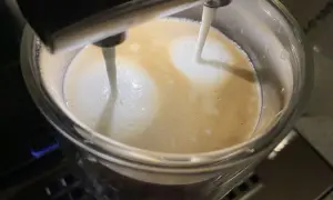 Mleko wlewa się do kawy z ekspresu Krups, tworząc piankę. Szkoda, że ekspres Krups nie spienia mleka idealnie.