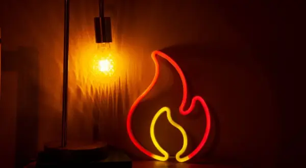 Neonowy płomień i żarówka tworzą ciepłą atmosferę. Czy to symbol grzejnika na podczerwień wady?