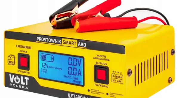 Żółty prostownik Volt Polska Smart A80 z wyświetlaczem, kablem i klemami. Urządzenie oferuje inteligentne ładowanie i rekondycjonowanie akumulatora, co może pomóc w odsiarczanie akumulatora.