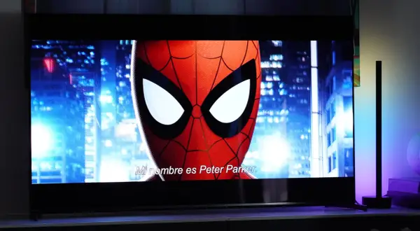 Spider-Man na ekranie telewizora, porównanie technologii QD OLED vs OLED. W tle nocne miasto.