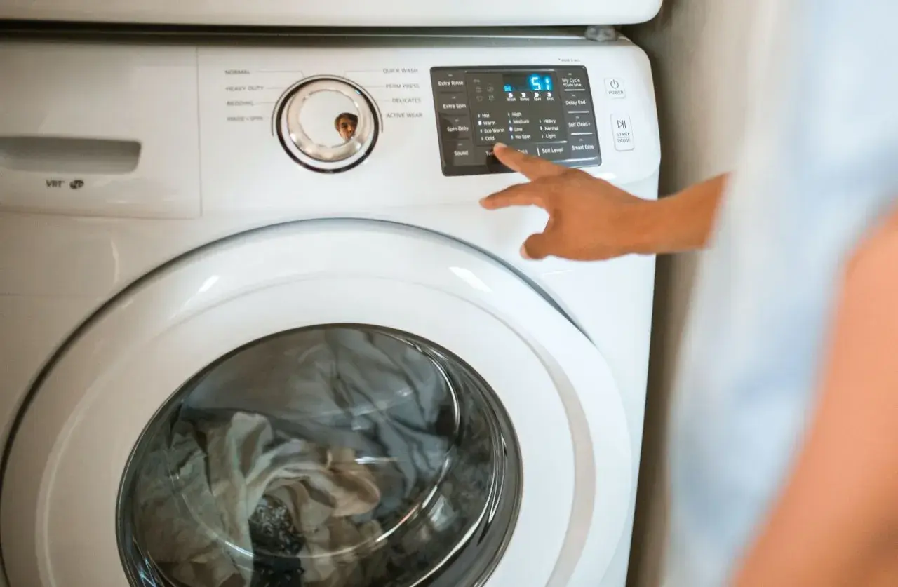 Pralka Whirlpool z włączonym programem. W razie awarii, drzwi można otworzyć awaryjnie.
