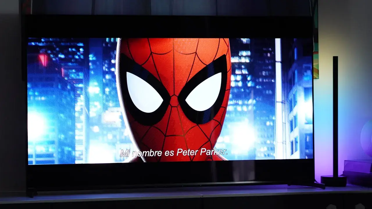 Spider-Man na ekranie telewizora, porównanie technologii QD OLED vs OLED. W tle nocne miasto.