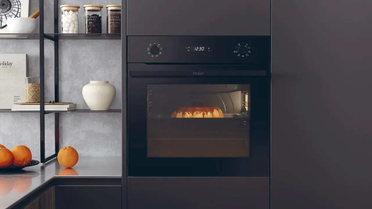 Nowoczesny piekarnik elektryczny Haier z ciastem w środku. Jego moc pozwoli na idealne wypieki.