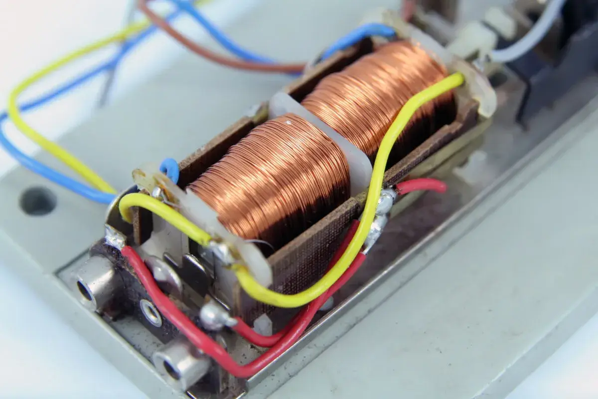 Cewki nawinięte miedzianym drutem tworzą elektromagnes. Połączone są kolorowymi przewodami, gotowe do działania.