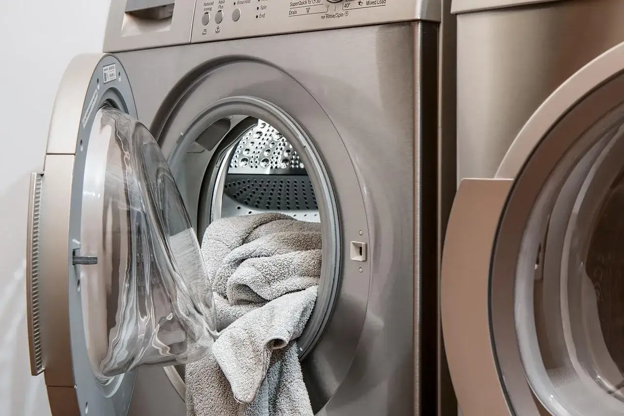 Pralka Gorenje z otwartymi drzwiczkami i ręcznikami w środku. Pojawił się błąd E07, co może oznaczać problem z odprowadzaniem wody.