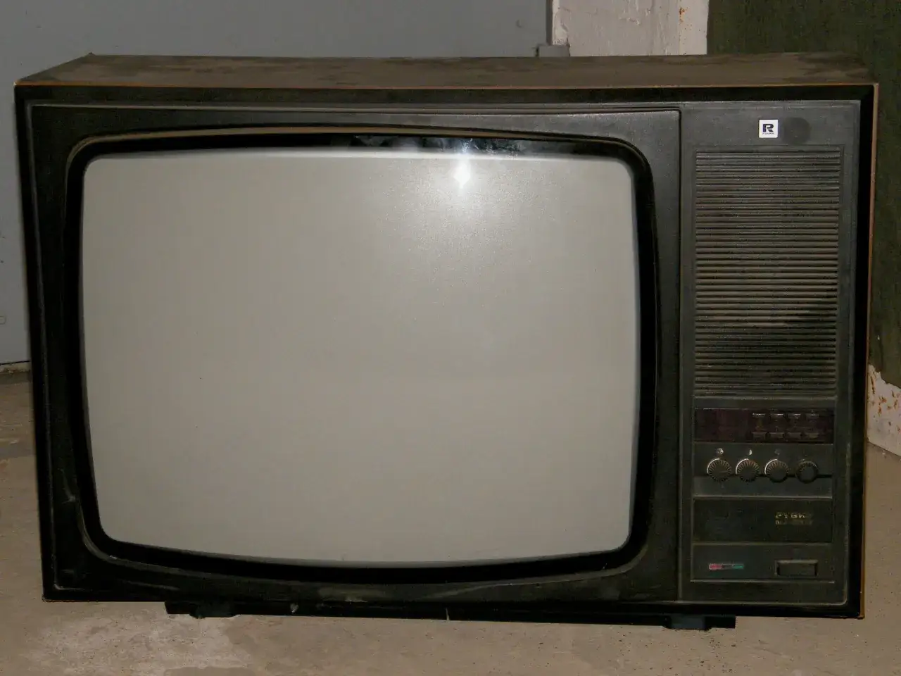 Stary telewizor Rubin, prawdopodobnie pierwszy telewizor w domu, z szarym ekranem i pokrętłami.